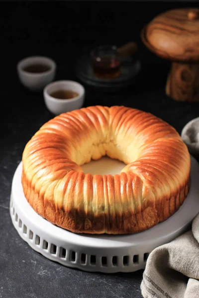 Wool Roll Ekmeği, Ev yapımı Japon Brioche Hokkaido Shokupan Süt Ekmeği Yün Gibi Güzel Dokuya sahip. Beyaz Tabakta, Siyah Koyu Mermer Arkaplanda Çay ile Servis Edildi