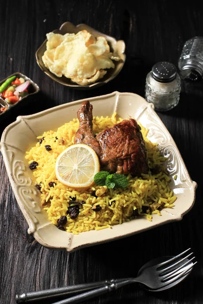 Turşulu biryani pilavı, kızarmış tavuk, papalık ve salata, beyaz arka planda geleneksel Hint yemeği.