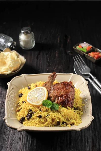 Nasi Briyani or Biryani Rice with Roast Chicken Leg is a Typical Middle East Food. Basmati Rice Cooked with Spices. Similar with Kabli, Kebuli, Mandhi, Kabsah Rice. Usually Served in the Muslim Eid or Lebaran Celebration.