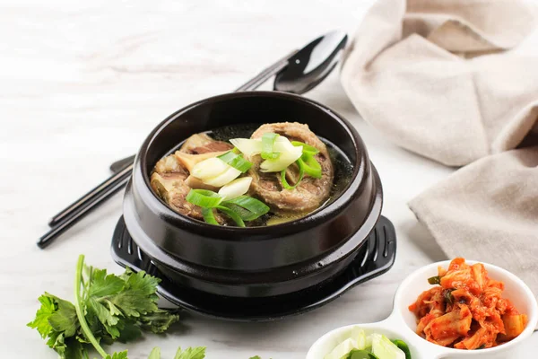 Gori Gomtang (Sokkori Gomtang) veya Kore Oxtail Çorbası, Kimchi ve Dilimlenmiş Yeşil Soğan ile birlikte Kara Kore Bowl 'unda servis edilir.