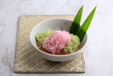 Putu Mayang ya da Petulo, Endonezya Geleneksel Pirinç Un İplikçikleri, Gıda Boyası ile bir top şeklinde kıvrılmış, Hindistan cevizi sütü ve Palm Sugar Syrup ile servis edilir. Beyaz Arkaplan 