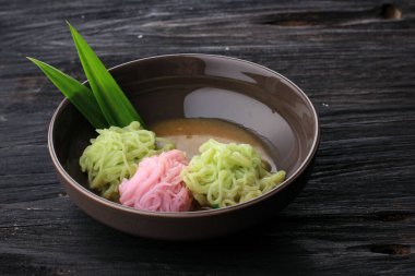 Endonezya Gıda: Putu Mayang veya Petulo, Endonezya Geleneksel Pirinç Un İplikçiklerinden Yapılmış Cava Çerezi, Hindistan cevizi sütü ve Palm Sugar şurubuyla servis edilen, besin renkleriyle bir topun içine kıvrılmış.