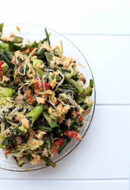 Üst Manzara Sayur, ahşap arka planda. Baharatlı hindistan cevizli sebze pişirdim. Endonezya geleneksel yemekleri. Boşluğu Beyaz Arkaplanda Kopyala