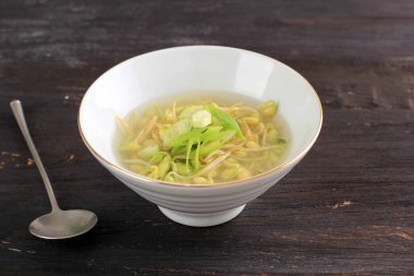 Pirinçli soya filizli çorba (Kongnamul Gukbap) Kore Gıda Tazeleme, Beyaz Kase 'de servis, Dilimlenmiş Yeşil Soğanlı Kara Tahta Masa.