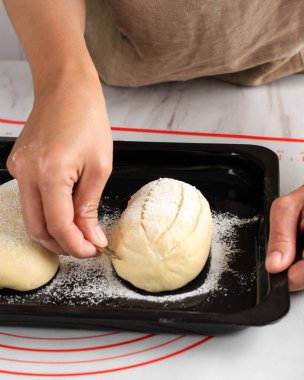 Pişirme Süreci: Ekmek Yapımı, Çiğ Yuvarlak Japon Süt Çubuğu Ekmek Hamuru Puanı. Kadın El Hamur Usturası Kullanırken Haç Kesimi