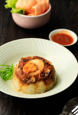 Ev yapımı Nasi Tim Ayam Jamur (Tavuk ve Mushrom Buharlı Pirinç) ve Soya Sosu ve Kaynamış Yumurta. Cracker ve Sambal ile hizmet. 