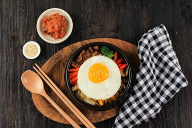 Bibimbap, pirinçli Kore Baharatlı Salata ve üstüne kızarmış yumurta, geleneksel Kore Karışık Pirinç Tarzı. Tahta Masada Üst Görünüm