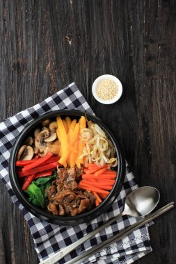 Bibimbap, pirinçli Kore Baharatlı Salata ve üstüne kızarmış yumurta, geleneksel Kore Karışık Pirinç Tarzı. Kara Tahta Masada Üst Görünüm