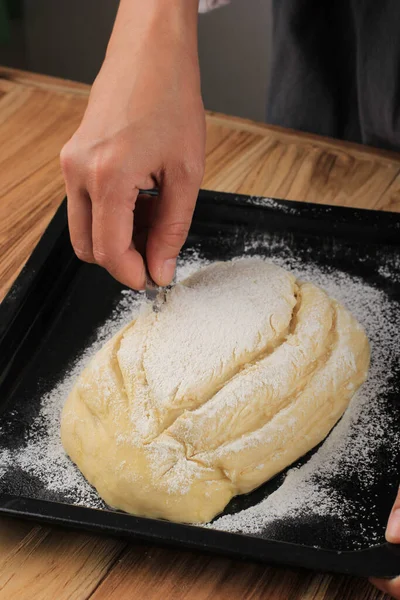 Baking Process: Making Bread, Scoring Raw Round Japanese Milk Hearth Bread Dough. Female Hand Making Cross Cut on the Top of Dough Using Razor