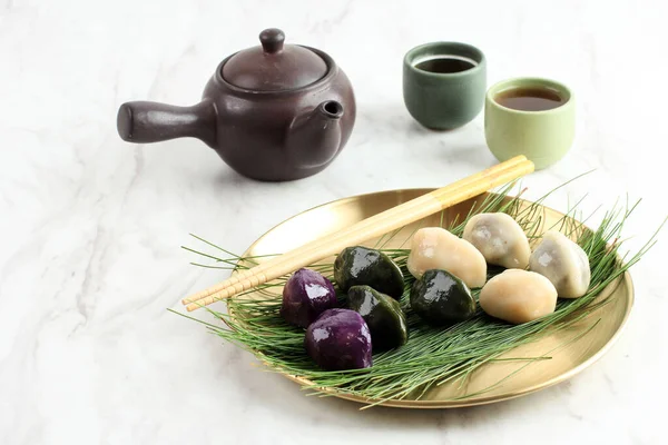 伝統的なチュソクの日の食べ物 韓国の半月形の餅やソンピョン 韓国米粉をセサミシードまたはチョップドナッツ ハニー またはレッドビーンペーストで作られ 紅茶と共に提供されます — ストック写真