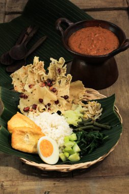 Nasi Pecel. Geleneksel Java Pirinç Buharlı Pirinç Tabağı Sebze Salatası, Fıstık Sosu Sosu, Tempeh, Tofu Fasulyesi ve Peyek Krakerleri. Pecel Madiun En Popüler Değişken