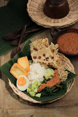 Nasi Pecel. Geleneksel Java Pirinç Buharlı Pirinç Tabağı Sebze Salatası, Fıstık Sosu Sosu, Tempeh, Tofu Fasulyesi ve Peyek Krakerleri. Pecel Madiun En Popüler Değişken