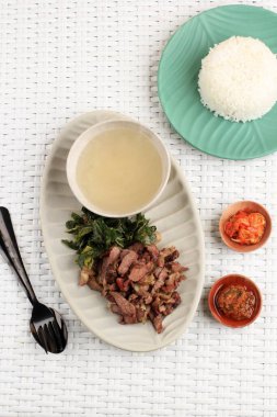 Se 'i Sapi veya Beef Sei Endonezya Geleneksel Tütsülenmiş Et, Kaynamış Cassava Yaprakları ve Sambal Luat veya Sambal Matah ile servis edilir. Endonezya, Nusa Tenggara 'dan tipik yiyecek. Üst Görünüm 