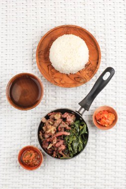 Se 'i Sapi veya Beef Sei Endonezya Geleneksel Tütsülenmiş Et, Kaynamış Cassava Yaprakları ve Sambal Luat veya Sambal Matah ile servis edilir. Endonezya, Nusa Tenggara 'dan tipik yiyecek. Üst Görünüm 