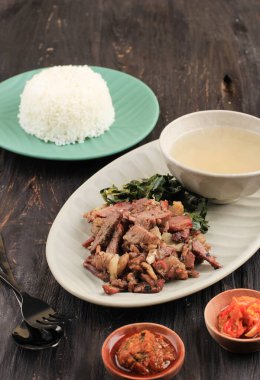 Se 'i Sapi veya Beef Sei Endonezya Geleneksel Tütsülenmiş Et, Kaynamış Cassava Yaprakları ve Sambal Luat veya Sambal Matah ile servis edilir. Endonezya, Nusa Tenggara 'dan tipik yiyecek.