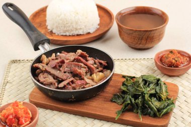 Se 'i Sapi veya Beef Sei Endonezya Geleneksel Tütsülenmiş Et, Kaynamış Cassava Yaprakları ve Sambal Luat veya Sambal Matah ile servis edilir. Endonezya, Nusa Tenggara 'dan tipik yiyecek.