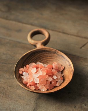 Bir kaşık Pembe Kristal Himalaya Tuzu Kırsal Ahşap Masa 'ya izole edilmiş Seçilmiş Odak 