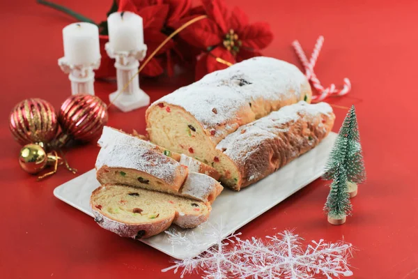 Yılbaşı Stollen 'ı taşra arka planında. Geleneksel Noel Şenlikli Pasta Tatlısı. Almanca. Noel için çalınmış, Kırmızı Konsept