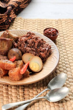 Seçili Odak Kılavuzu. Yogyakarta Endonezya 'dan imzalı ve efsanevi bir tabak. Jack Fruit Stew eşliğinde sığır derisi kraker ve kahverengi yumurta, tofu, Tempeh ve Sambal.