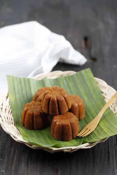 Bolu Sakura Steamed Caramel Cake, Made from Caramel with Cake Batter from Egg, Sugar, Flour, and Butter. Served on Wooden Plate with Banana Leaf. Copy Space for Text
