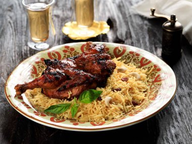 Tahta masada çay ile servis edilen Nasi Kebuli Ayam (Tavuk Pilav)