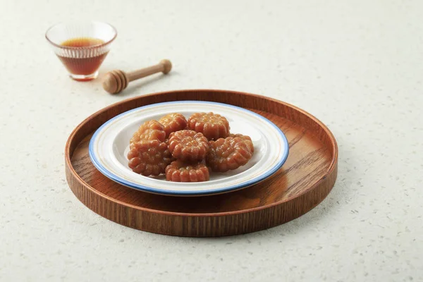 Yakgwa, Korean style honey cookie : Flour mixed with honey and sesame oil, pressed in a yakgwa pan (yakgwa mold), shallow-fried or deep-fried, dipped in grain syrup or honey