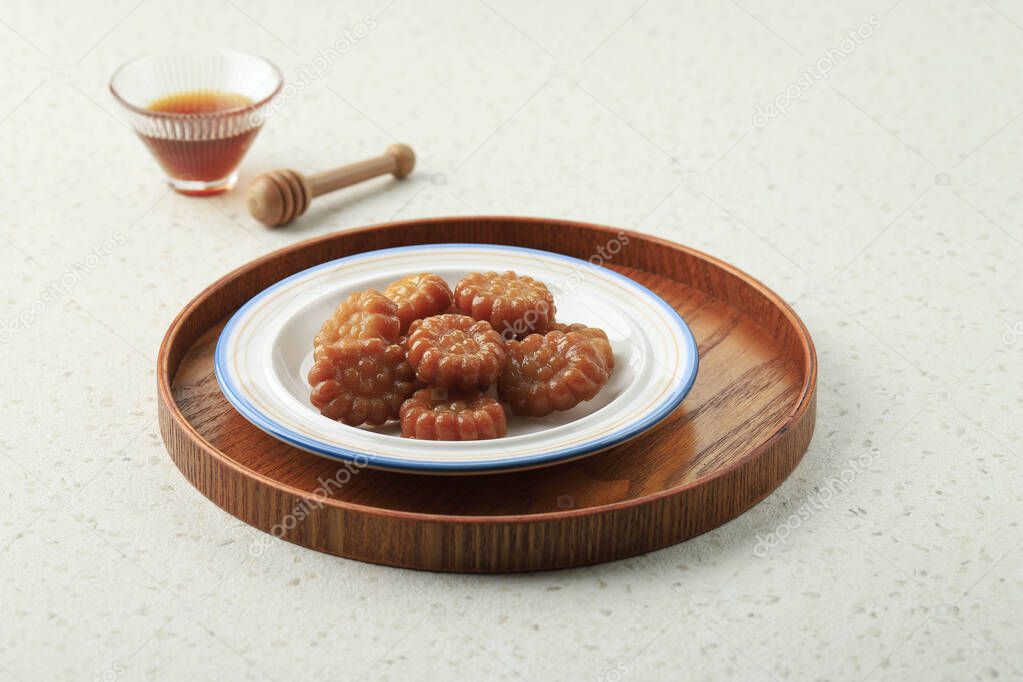 Yakgwa, Korean style honey cookie : Flour mixed with honey and sesame oil, pressed in a yakgwa pan (yakgwa mold), shallow-fried or deep-fried, dipped in grain syrup or honey