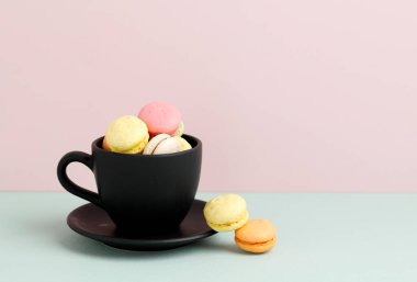Siyah Kupa 'daki mini Macaroon, Pastel Arkaplan' daki Boşluğu Kopyala. Metin veya Reklam için Boşluğu Kopyala