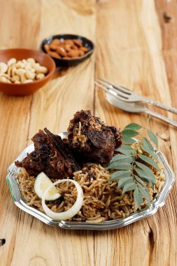 Nasi Kebuli Iga Kambing ya da Kabli Rice Pulao ve Koyun Pirzola Gözlü Tahta Masa. Aile İçin Ied al Adha Menüsü