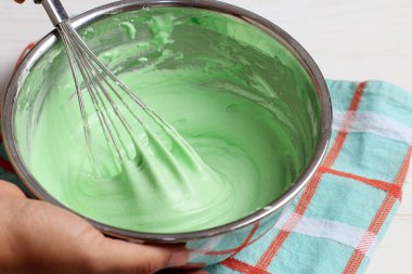 Green Batter 'la Whisk' ı Paslanmaz Kâse 'yle karıştır. Kâseyi Kadın Eli Tutuşu, Yemek Pişirme veya Pişirme Süreci
