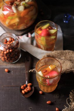 Asinan Buah Bogor ya da Rujak Buah, Tatlı, Ekşi ve Baharatlı Kırmızı Çorba Dilimlenmiş Tropikal Meyvelerden yapılmış Meyve Turşusu. Ramadhan 'da ünlü kızarmış fıstıkla kaplanmış..