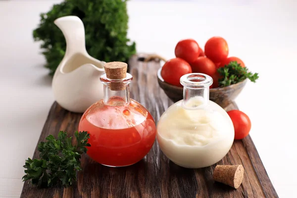 Spicy Sauce and Mayonaise on Small Bottle above White Wooden Table