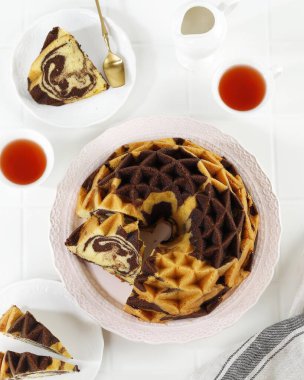 Top View mermer kek, Pound Cake veya tereyağlı pasta dilimlenmiş, çay ile servis edilir. Beyaz Masa Üzerinde