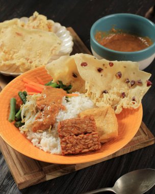 Nasi Pecel, Indonesian Traditional Menu with Spicy Peanut SAuce, Tempeh, Boiled Vegetable, and Fried Tofu, Rempeyek, Popular for Breakfast, Dinner, or Lunch from East Java