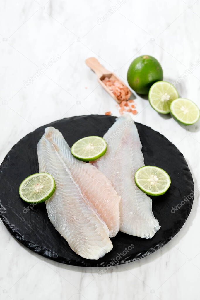 John Dory Fillet, Saint Peter Fillet with Lime and Salt. On White Table. Copy Space 