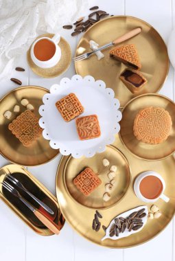 Mooncake Chinese Traditional Pastry,  Moon Cake with Tea Cups on White Wooden Background for Mid Autumn Festival. Top View 