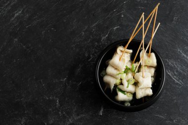 Odeng Oemuk Guk, Skewer Fish Cake Korean Popular Street Food Soup, Top View on Black Marble Table