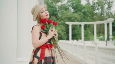 Kırmızı güllü Retro kız. Sevdiği biri tarafından sunulan kırmızı gülleri olan bir kız onu düşünüyor ve onu tekrar görmeyi hayal ediyor..