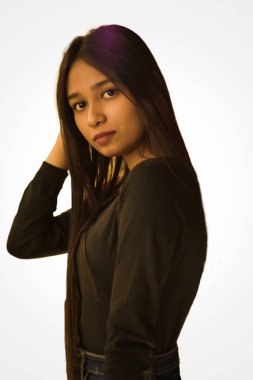 Siyah kıyafetli zarif bir bayanın izole edilmiş portresi yan yana kameraya bakıyor.