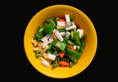 Sarı kasede doğranmış havuç, turp, fasulye, bezelye.