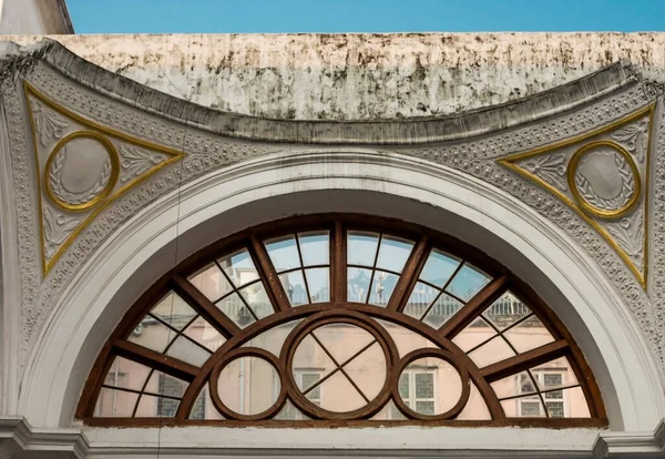 A semi circle window with wooden frame lines in a vintage style building.