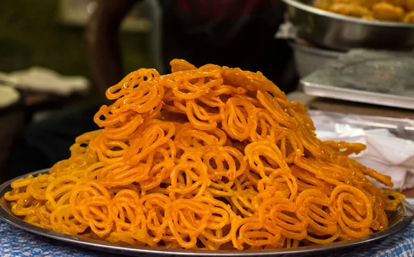 Jalebi yığını, yağda kızartılmış ve şeker şurubuna batırılmış Hint tatlısı. Seçici odaklanma. Arkaplan bulanıklığı.