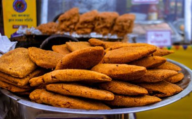 Çelik bir tabakta bir yığın tavuk pirzolası. Arkaplan bulanıklığı olan seçici odak.