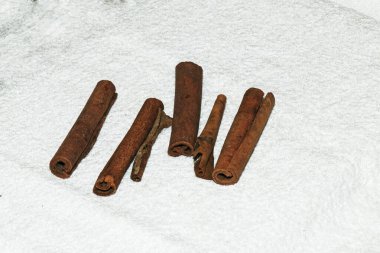 Çay karışımı yapmak için tarçın çubukları. Tarçın beyaz bir beze yapışır. Sağlıklı gıda konsepti.