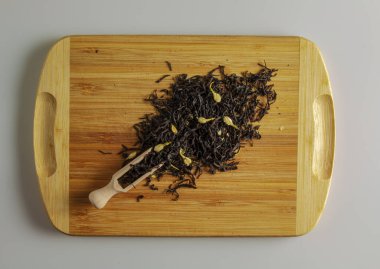 Çay demlenmeye hazır. Çay demlemek için Spatula. Kurumuş yasemin çiçekleriyle kokulu siyah çay yaprakları. Tahtadaki çay..