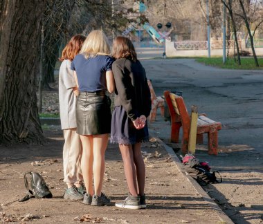 Dnipropetrovsk, Ukrayna - 11.25.2021: Okuldan sonra tartışan üç kızın arkasından manzara.