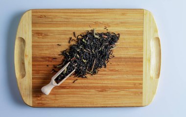 Çay demlenmeye hazır. Çay demlemek için Spatula. Limonlu siyah çay yapraklarının arka planı. Tahtadaki çay..