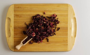 Kurutulmuş nar çiçeklerinden yapılan çay. Bağışıklığı arttırır. Ahşap bir spatula, çay ve bir avuç çay karışımı..