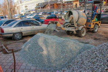 Dnipropetrovsk, Ukrayna - 11.22.2021: İnşaat alanında taşınabilir beton karıştırıcı. Beton yapmak için çakıl yükleniyor.
