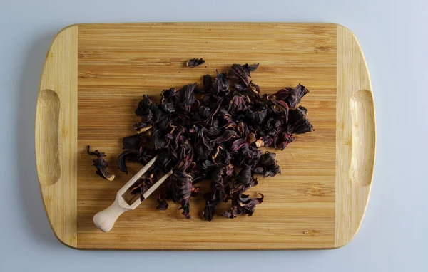 Kurutulmuş nar çiçeklerinden yapılan çay. Bağışıklığı arttırır. Ahşap bir spatula, çay ve bir avuç çay karışımı..